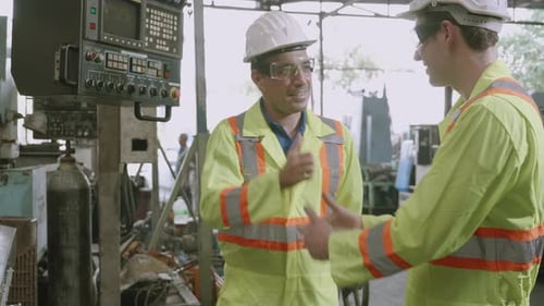 Two maintenance man and partner work with system of machine in industrial factory.