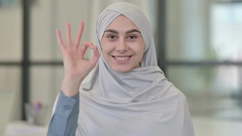 Junge arabische Frau zeigt Okay Zeichen