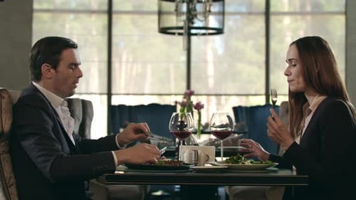 Happy Couple Dining in Restaurant. Woman Taking Food From Man Plate at Dinner