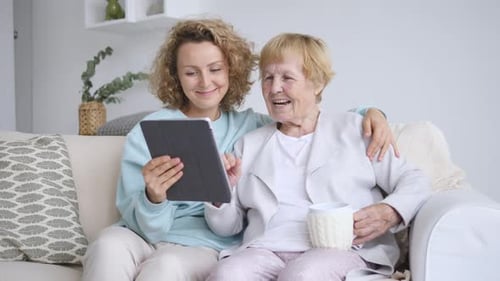 Woman and Senior Woman Using Tablet at Home