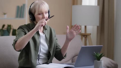 Woman with Headset on Laptop Video Call at Home