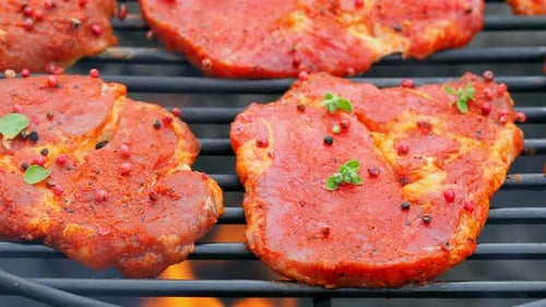 Raw pork neck with spices on a hot grill with fire, Poland