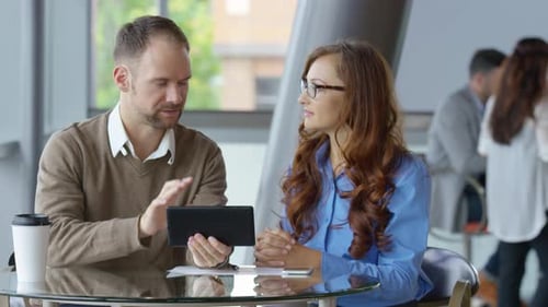 Zwei junge Geschäftsleute nutzen digitales Tablet