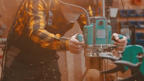 Woodworker Using Machine to Trim Edge of Wood