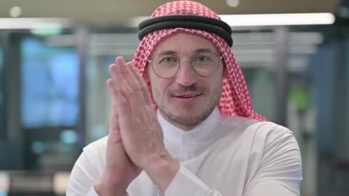 Smiling Man Clapping in Office Setting