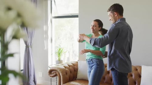 Playful Couple Slow Dancing Together at Home