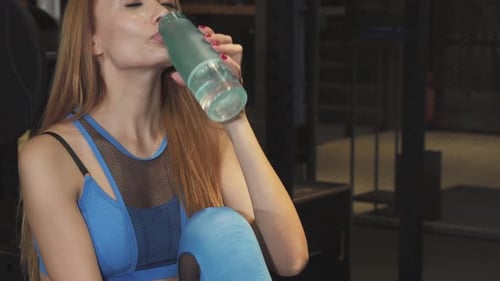 Beautiful Happy Fitness Woman Smiling Drinking Water After Gym Training
