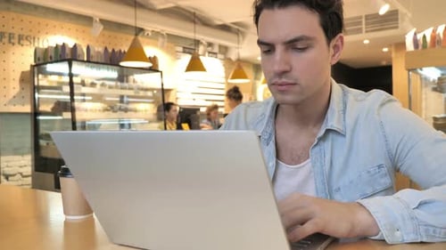Casual Man Busy Working on Laptop in Cafe