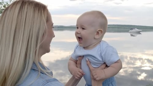 Cheerful Mother Lifting Baby in Air
