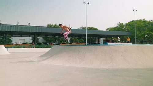 Young Adult Male Skateboarding on Ramp in Skatepark