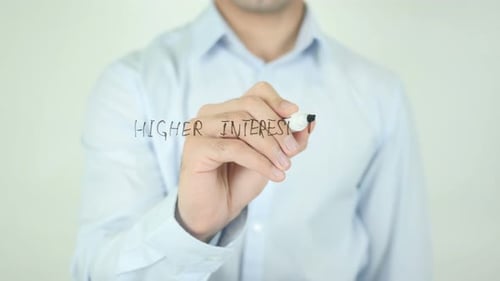 Man Writes Higher Interest Rates on Clear Surface