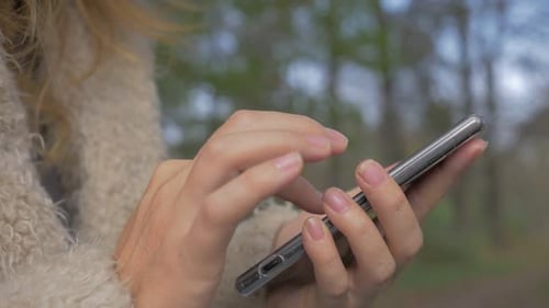 Woman Using Smartphone in Nature on Overcast Day