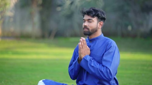 Man Meditating Outside in Traditional Clothing