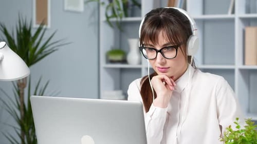 Young Adult Woman Working on Laptop with Headphones