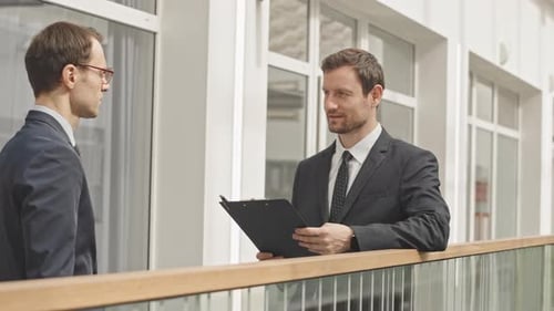 Geschäftsleute in Anzügen sprechen über Arbeit in Innenräumen