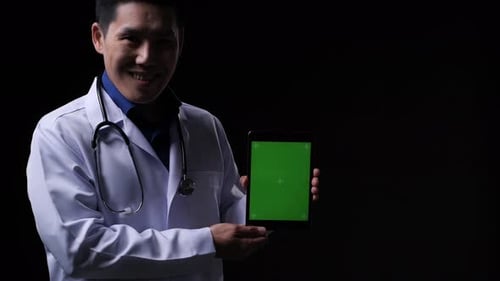 Smiling Doctor Presenting Tablet with Green Screen
