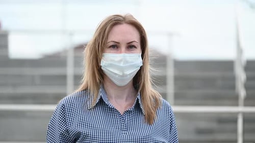 Woman Wearing a Mask in an Urban Setting