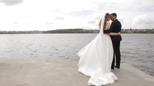 Loving Couple Embracing on Pier by Lake