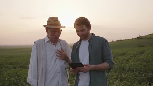 Close Up View of Two Farmers with a Black Tablet