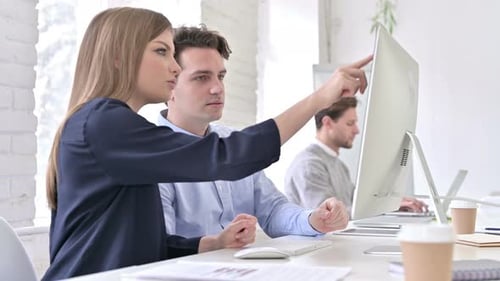 Colleagues Collaborate at Computer in Bright Office