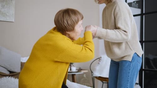 Woman Embraces Senior Woman in Bedroom