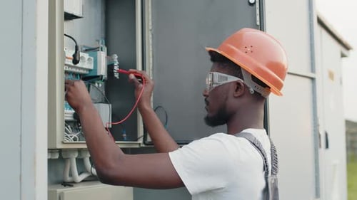 Construction Worker Using Voltmeter on Electrical Panel