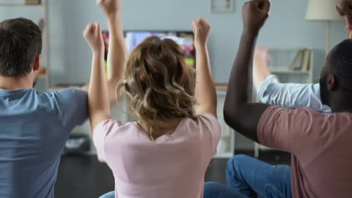 Friends Cheer While Watching Sports on Television