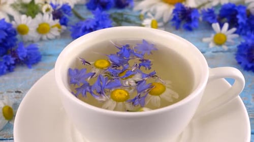 Brasser des tisanes à partir de centaurées et de camomille dans une tasse blanche.