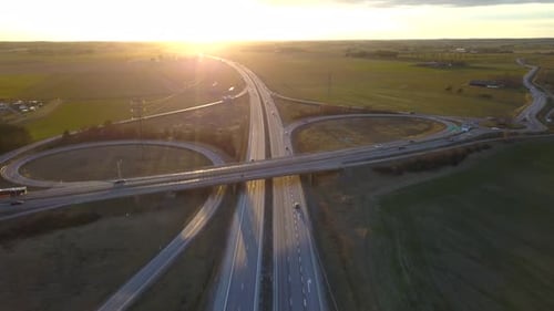 Aerial view of freeway intersection with moving traffic cars.