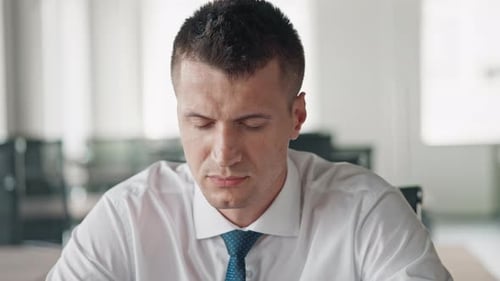 Confident Young Professional Stares Intently at Camera