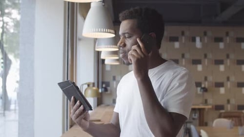 Young Adult Working with Tablet and Cellphone