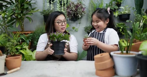 Mother teaching daughter to plant trees