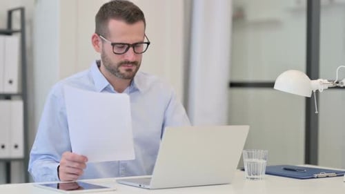 Professional Man Working With Laptop and Papers