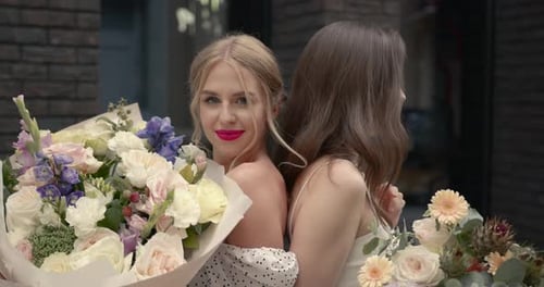 Elegant Women with Bouquets Posing in the City