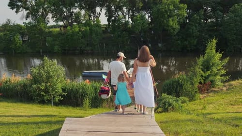 Family Walks Toward Lake on Sunny Day