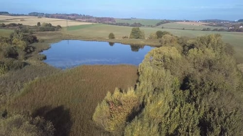 flying in countryside with beautiful spring with small pond.