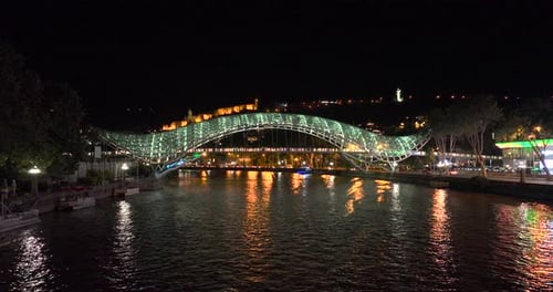 Night aerial view of Bridge of Peace and beautiful cityscape in the center of Tbilisi, Georgia 2022