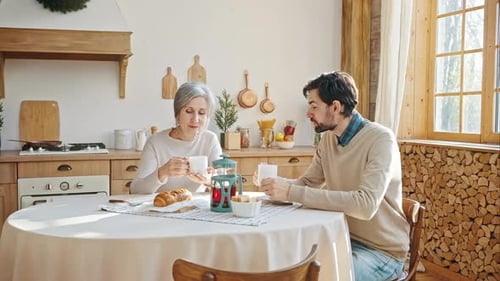 Adult Son and Senior Mother Sharing Coffee