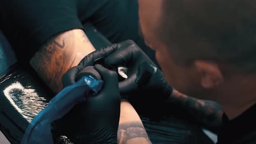 Tattoo Artist Working on a Tattoo in Studio