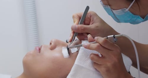 Esteticista e jovem mulher em um salão de beleza com extensão de cílios