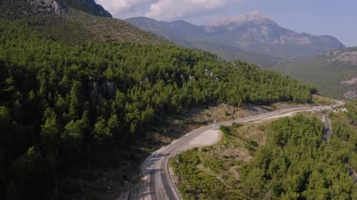 Aerial View of Mountain Road Going Through Forest Landscape