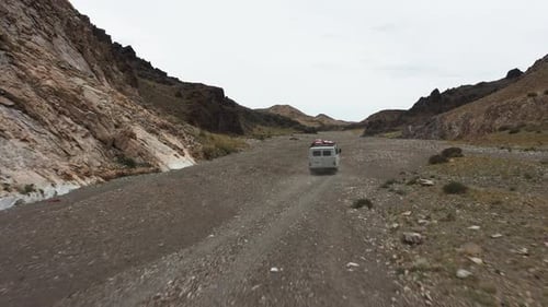 Offroad Vehicle Goes on a Dirt Road Among the Mountains