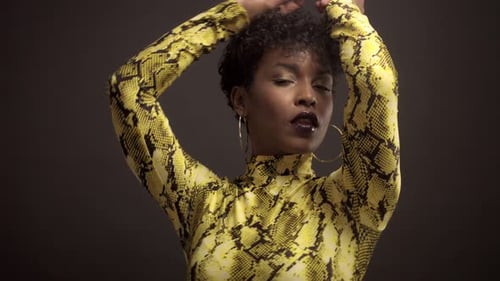 Femme afro-américaine en robe jaune vif à imprimé python