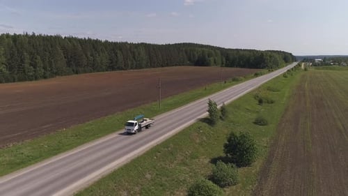 Aerial view of truck crane driving on a straight asphalt road 06