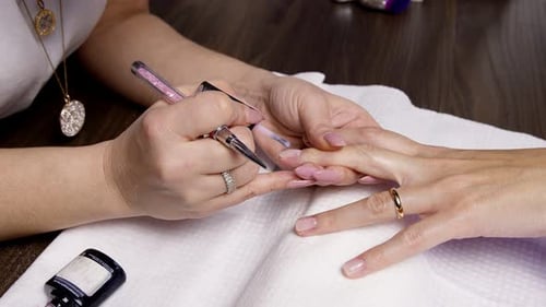 Manicurist Applies Clear Coat to Elegant Manicured Nails