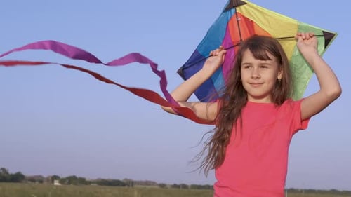 Happy Girl Holding Kite in Grassy Field