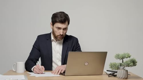 Professional Man Working at Desk With Laptop