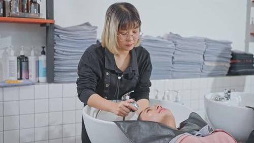 Hair Stylist Washing Client's Hair at Salon