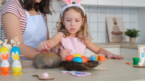 Mother and Daughter Painting Easter Eggs with Rabbit