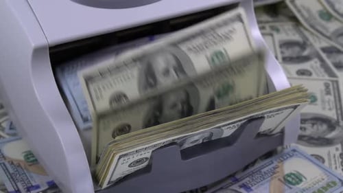 Currency Counter Counts Stacks of 100 Dollar Bills